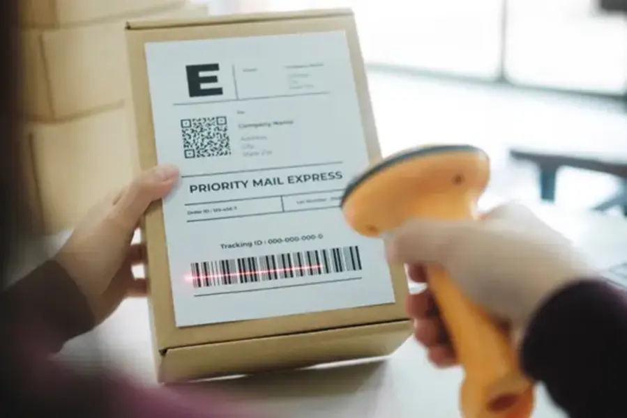 A courier man scanning a barcode on a shipping label before delivery