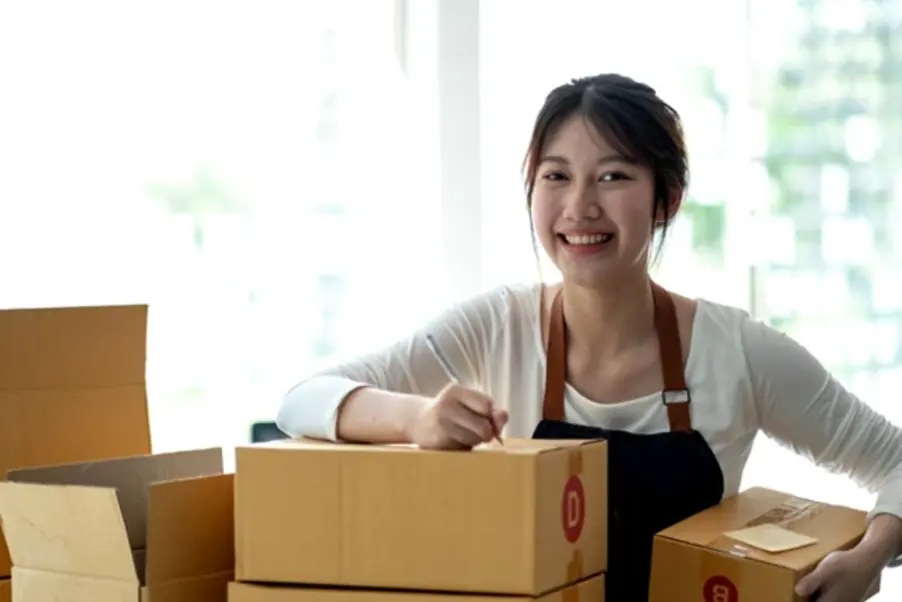 A woman preparing a parcel for delivery