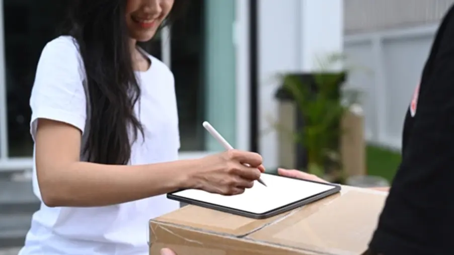 A woman receiving a package and completing the delivery confirmation