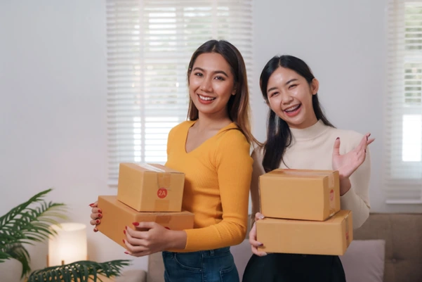 Two women holding two packages